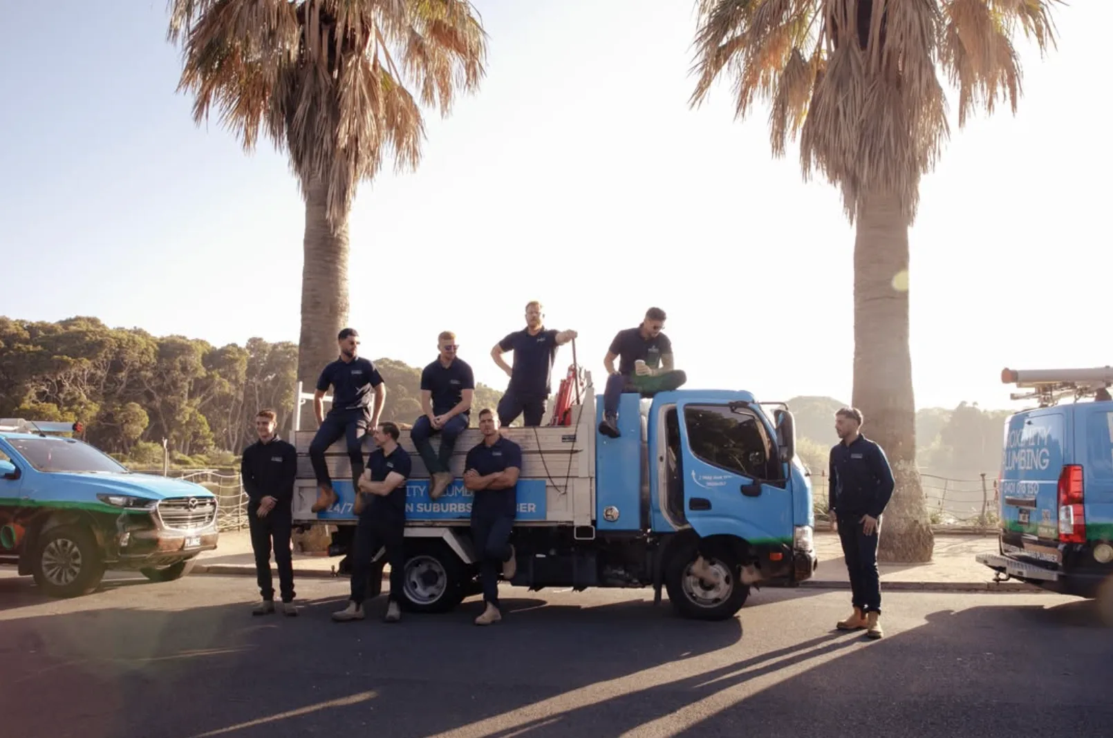 The local drain crew with their trucks by the beach