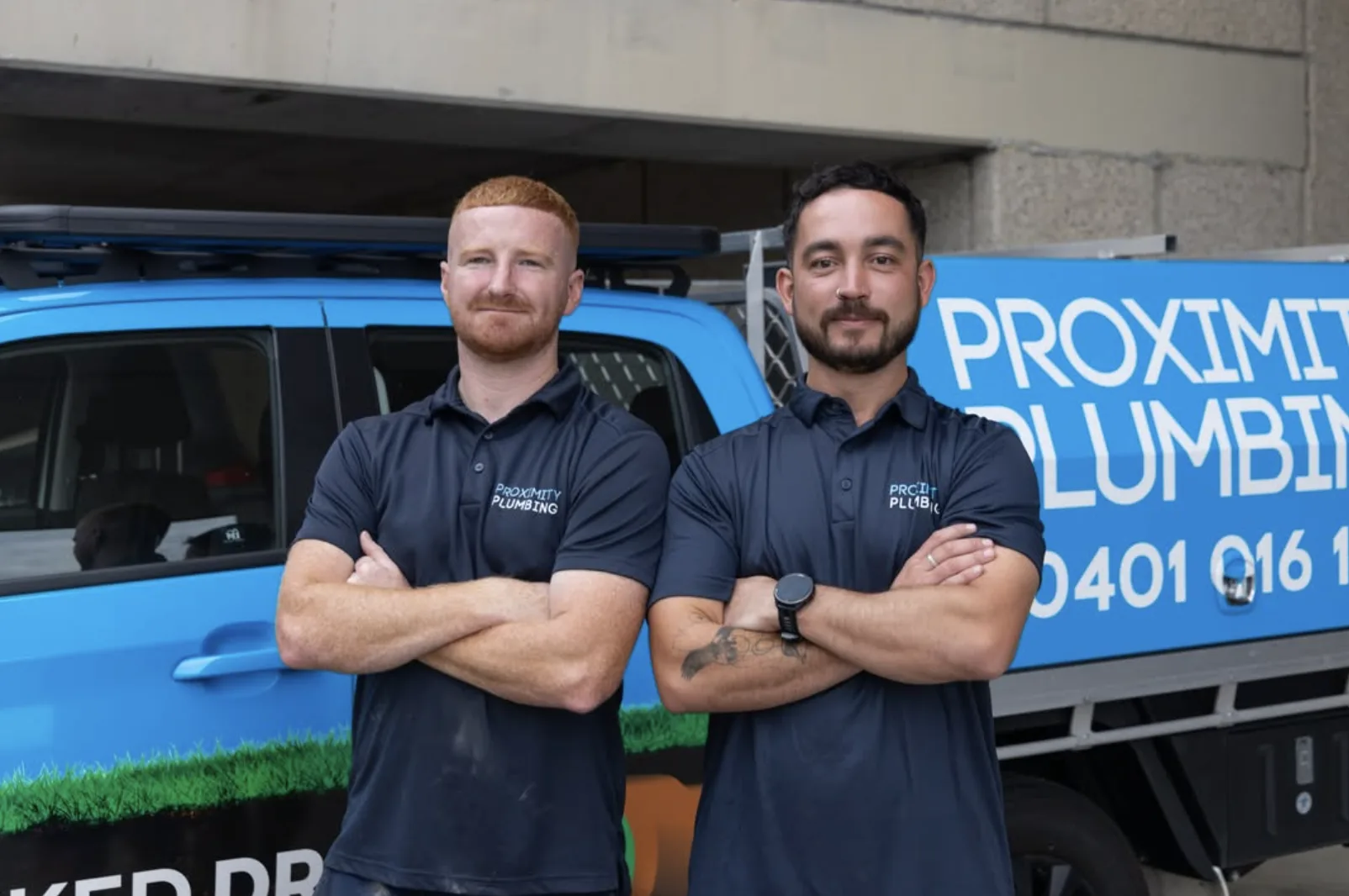 Two licensed plumbers in front of a fully stocked service van